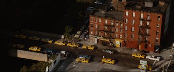 Movie still from “'Round Midnight” (1986), directed by Bertrand Tavernier – A bunch of yellow taxis are parked in a parking lot; Extreme Wide shot, High angle