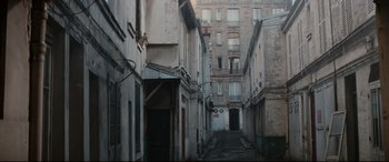 Movie still from “'Round Midnight” (1986), directed by Bertrand Tavernier – An alley way in an urban area with buildings in the background; Extreme Wide shot, High angle