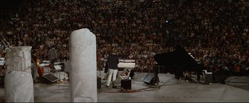 Movie still from “'Round Midnight” (1986), directed by Bertrand Tavernier – A crowd of people watching a man play a piano; Extreme Wide shot, High angle