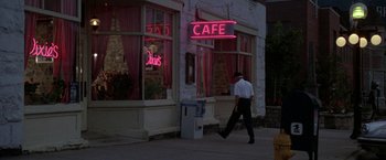 Movie still from “Roxanne” (1987), directed by Fred Schepisi – A man walking down the sidewalk in front of a cafe; Wide shot, High angle