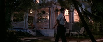 Movie still from “Roxanne” (1987), directed by Fred Schepisi – A man walking down the sidewalk in front of a house; Wide shot, Low angle