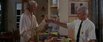 Movie still from “Roxanne” (1987), directed by Fred Schepisi – A man and a woman holding wine glasses at a dinner table; Medium shot, Low angle