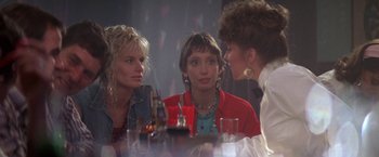 Movie still from “Roxanne” (1987), directed by Fred Schepisi – A group of women sitting at a table talking to each other; Medium shot, Over the shoulder angle