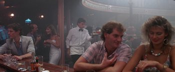 Movie still from “Roxanne” (1987), directed by Fred Schepisi – A man sitting at a table in front of a waitress; Medium shot, Over the shoulder angle