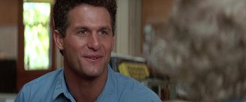 Movie still from “Roxanne” (1987), directed by Fred Schepisi – A person wearing a blue shirt smiling; Close Up shot, Low angle