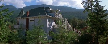 Movie still from “Roxanne” (1987), directed by Fred Schepisi – A white building with stairs going up to the top of it; Extreme Wide shot, Low angle