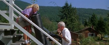 Movie still from “Roxanne” (1987), directed by Fred Schepisi – An older man and a young woman looking through a telescope; Medium shot, High angle