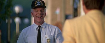 Movie still from “Roxanne” (1987), directed by Fred Schepisi – A man wearing a hat and a tie; Close Up shot, Over the shoulder angle