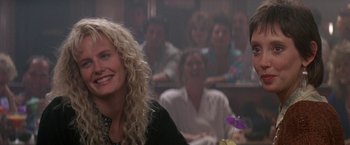 Movie still from “Roxanne” (1987), directed by Fred Schepisi – A group of people sitting in a room; Close Up shot, Over the shoulder angle