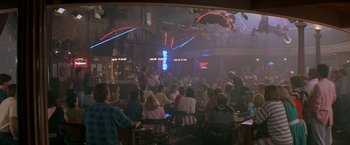 Movie still from “Roxanne” (1987), directed by Fred Schepisi – A crowd of people sitting at tables in a bar; Extreme Wide shot, High angle