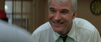 Movie still from “Roxanne” (1987), directed by Fred Schepisi – A person wearing a shirt and tie; Close Up shot, Over the shoulder angle