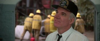 Movie still from “Roxanne” (1987), directed by Fred Schepisi – A man wearing a fireman's hat looks up into the sky; Close Up shot, Low angle