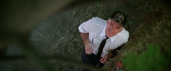 Movie still from “Roxanne” (1987), directed by Fred Schepisi – An aerial view of a man in a white shirt and tie; Medium shot, Overhead angle