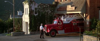 Movie still from “Roxanne” (1987), directed by Fred Schepisi – A man walking in front of a fire truck; Wide shot, Low angle