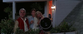 Movie still from “Roxanne” (1987), directed by Fred Schepisi – A woman holding a telescope in front of people; Medium shot, Low angle