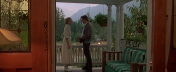 Movie still from “Roxanne” (1987), directed by Fred Schepisi – A man and a woman standing on the porch of a house; Wide shot, Low angle