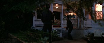 Movie still from “Roxanne” (1987), directed by Fred Schepisi – Two people standing on the steps of a house at night; Wide shot, Low angle
