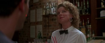 Movie still from “Roxanne” (1987), directed by Fred Schepisi – A woman in white shirt and black bow tie holding a drink; Close Up shot, Low angle