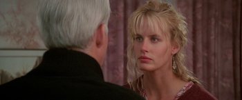 Movie still from “Roxanne” (1987), directed by Fred Schepisi – A woman looking into a mirror while standing next to an older man; Close Up shot, Over the shoulder angle