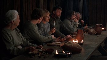 Movie still from “Royal Deceit” (1994), directed by Gabriel Axel – A group of people sitting around a table eating pizza; Medium shot, High angle