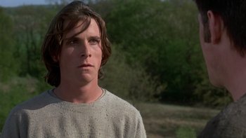 Movie still from “Royal Deceit” (1994), directed by Gabriel Axel – A man with long brown hair wearing a gray shirt; Close Up shot, Low angle