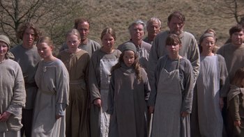 Movie still from “Royal Deceit” (1994), directed by Gabriel Axel – A group of people standing in a field with trees in the background; Wide shot, High angle