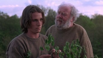 Movie still from “Royal Deceit” (1994), directed by Gabriel Axel – A man standing next to another man holding a plant; Close Up shot, Over the shoulder angle