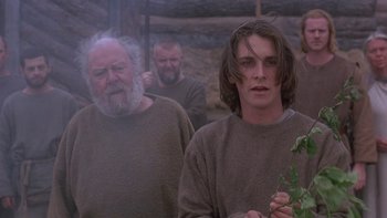 Movie still from “Royal Deceit” (1994), directed by Gabriel Axel – Two men and a woman standing next to each other; Medium shot, Low angle