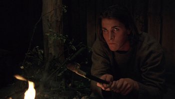 Movie still from “Royal Deceit” (1994), directed by Gabriel Axel – A man holding an axe in front of a tree; Medium shot, Low angle