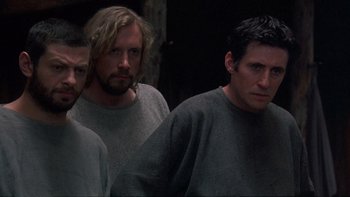 Movie still from “Royal Deceit” (1994), directed by Gabriel Axel – A group of men standing next to each other in a room; Medium shot, Low angle