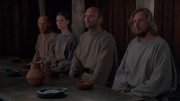 Movie still from “Royal Deceit” (1994), directed by Gabriel Axel – A group of people sitting around a table; Medium shot, Low angle
