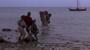 Movie still from “Royal Deceit” (1994), directed by Gabriel Axel – A group of people in the water with a boat in the background; Extreme Wide shot, High angle