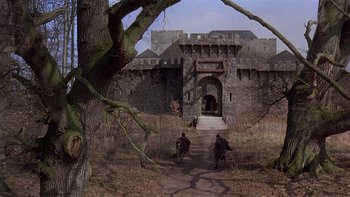 Movie still from “Royal Deceit” (1994), directed by Gabriel Axel – Two men are walking down a path in front of a castle; Extreme Wide shot, High angle