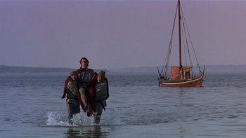Movie still from “Royal Deceit” (1994), directed by Gabriel Axel – A group of people in the water with a boat in the background; Wide shot, Low angle