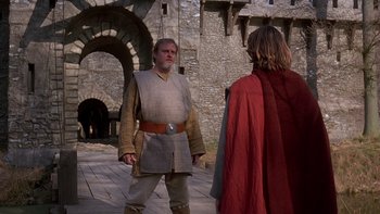 Movie still from “Royal Deceit” (1994), directed by Gabriel Axel – A man in a medieval outfit and a man in a red cape; Medium shot, Over the shoulder angle
