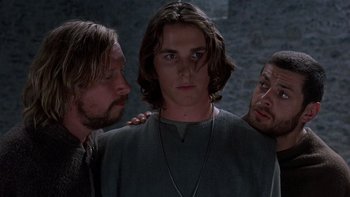 Movie still from “Royal Deceit” (1994), directed by Gabriel Axel – A group of men standing next to each other in front of a stone wall; Close Up shot, Low angle