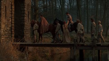 Movie still from “Royal Deceit” (1994), directed by Gabriel Axel – A group of people on a bridge with a horse; Wide shot, High angle
