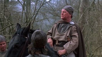Movie still from “Royal Deceit” (1994), directed by Gabriel Axel – A man in a medieval outfit talking to another man; Medium shot, Over the shoulder angle