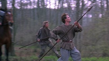 Movie still from “Royal Deceit” (1994), directed by Gabriel Axel – Two men in medieval garb are running through the woods; Wide shot, Low angle