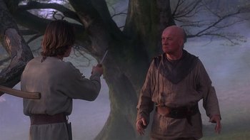 Movie still from “Royal Deceit” (1994), directed by Gabriel Axel – A man and a woman in medieval garb in front of a tree; Medium shot, Over the shoulder angle