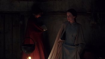 Movie still from “Royal Deceit” (1994), directed by Gabriel Axel – Two people standing next to each other near a candle; Medium shot, Over the shoulder angle