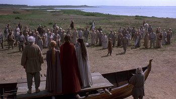 Movie still from “Royal Deceit” (1994), directed by Gabriel Axel – A group of people standing on top of a boat in a field; Extreme Wide shot, High angle