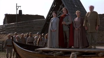 Movie still from “Royal Deceit” (1994), directed by Gabriel Axel – A group of people standing on top of a wooden boat; Wide shot, Low angle