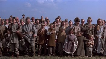 Movie still from “Royal Deceit” (1994), directed by Gabriel Axel – A large group of people standing in a grassy field; Wide shot, High angle