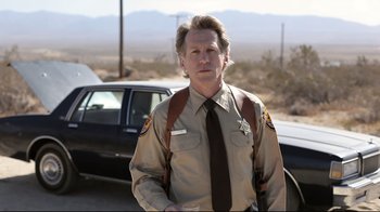 A man in a uniform standing in front of a car