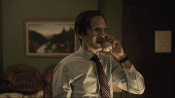 A man talking on a phone while wearing a tie