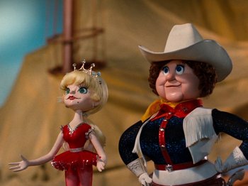 Movie still from “Rudolph and Frosty's Christmas in July” (1979), directed by Jules Bass – A couple of dolls that are next to each other; Medium shot, Low angle
