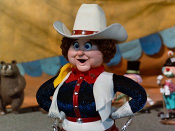 Movie still from “Rudolph and Frosty's Christmas in July” (1979), directed by Jules Bass – A doll wearing a cowboy hat; Close Up shot, Low angle