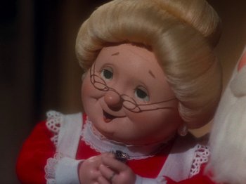 Movie still from “Rudolph and Frosty's Christmas in July” (1979), directed by Jules Bass – A doll's face , wearing glasses; Close Up shot, Low angle