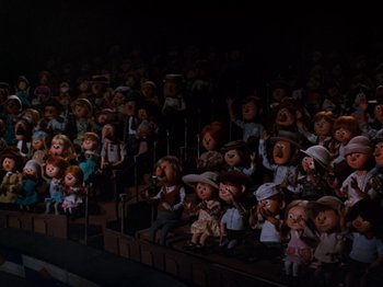 Movie still from “Rudolph and Frosty's Christmas in July” (1979), directed by Jules Bass – A crowd of people that are sitting in a stadium; Wide shot, Low angle